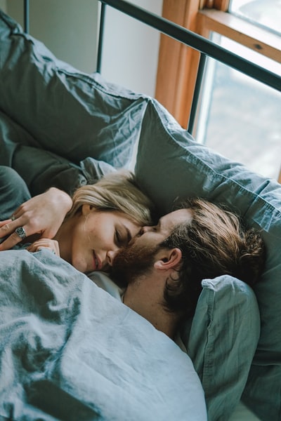 男人躺在床上亲吻女人的额头